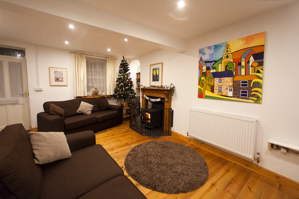 The living room with Christmas tree, and fireplace with wood burning stove - Sorgente Cornish Holiday Cottage in Penryn near Falmouth, Cornwall